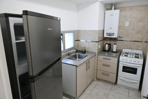 a small kitchen with a refrigerator and a sink at Parana Zona Parque in Paraná