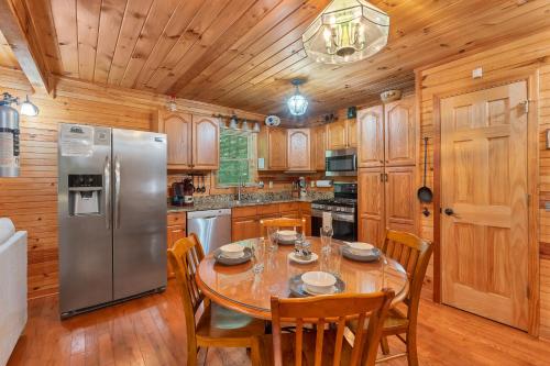 a kitchen with a table and a stainless steel refrigerator at Whiskey in the Woods in Townsend