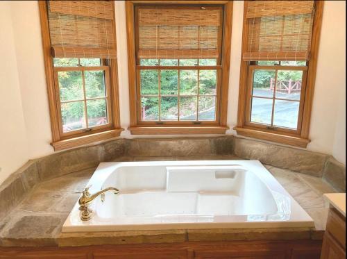 a large white bath tub in a room with windows at Mountain Peace in Townsend