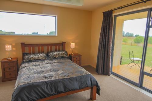 a bedroom with a bed and a sliding glass door at AislingQuoy in Amberley