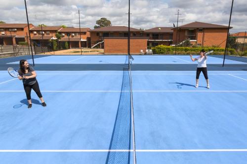two women playing tennis on a tennis court at Hunts Hotel Liverpool in Liverpool