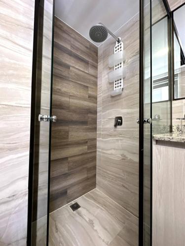 a shower with a glass door in a bathroom at Cozy smart studio & home office in La Paz