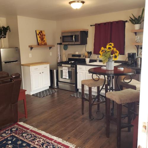 a kitchen with a table and a stove top oven at Van Gogh Get HIGH Tiny Home in Colorado Springs
