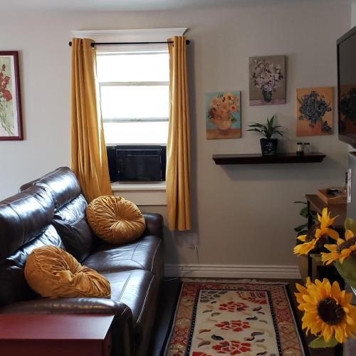 a living room with a leather couch and a window at Van Gogh Get HIGH Tiny Home in Colorado Springs