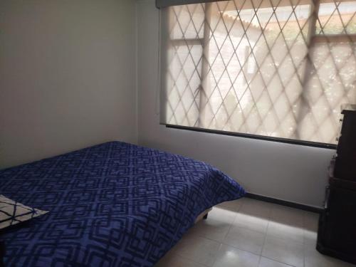 a bedroom with a bed in front of a window at El Manantial de Sopo in Sopó