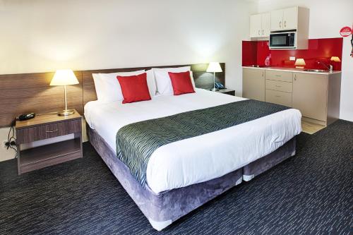 a hotel room with a large bed with red pillows at Hunts Hotel Liverpool in Liverpool