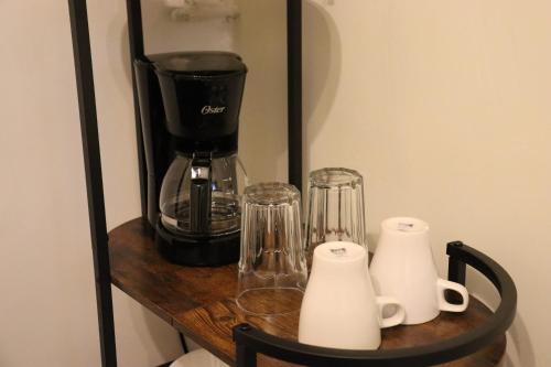 a shelf with a coffee maker and cups on it at Casa Nápoles in Mexico City