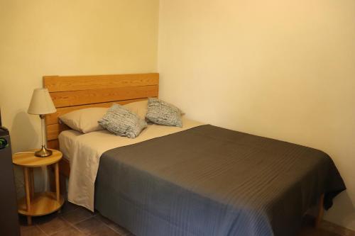 a small bedroom with a bed and a lamp at Casa Nápoles in Mexico City