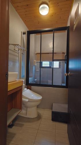 a bathroom with a toilet and a sink and a window at 木Box田妍山色 in Jiaoxi