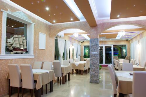 Un comedor con mesas y sillas blancas. en "HOLIDAY" apartments & rooms, en Ulcinj