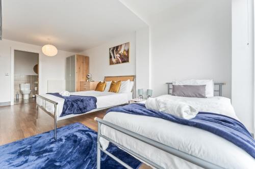 a bedroom with two beds and a blue rug at Birmingham City Centre Sunset Park Free Parking in Birmingham