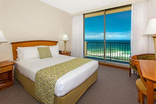 a bedroom with a bed and a view of the ocean at Noah's On the Beach in Newcastle