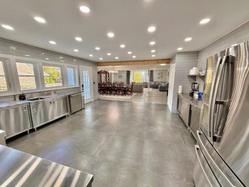 a large kitchen with stainless steel appliances and a living room at Ultimate Luxury Villa - Pool, Sauna, Hot Tub & More in Paterson