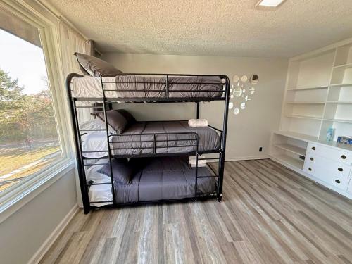 a room with two bunk beds with a window at Ultimate Luxury Villa - Pool, Sauna, Hot Tub & More in Paterson
