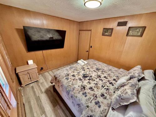 a bedroom with a bed and a tv on the wall at Ultimate Luxury Villa - Pool, Sauna, Hot Tub & More in Paterson