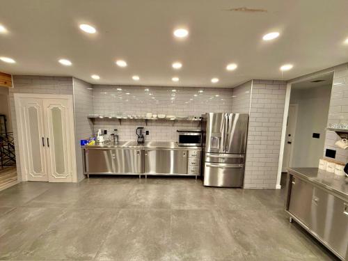 a large kitchen with stainless steel appliances at Ultimate Luxury Villa - Pool, Sauna, Hot Tub & More in Paterson