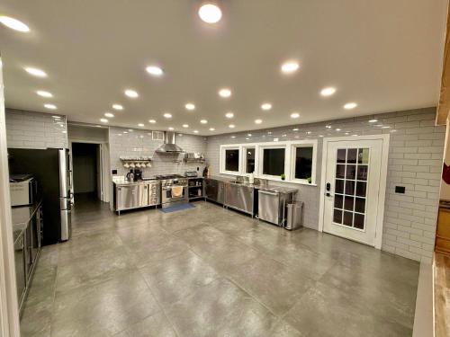 a large kitchen with stainless steel appliances at Ultimate Luxury Villa - Pool, Sauna, Hot Tub & More in Paterson