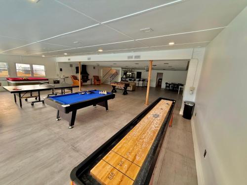 a room with a pool table and ping pong tables at Ultimate Luxury Villa - Pool, Sauna, Hot Tub & More in Paterson