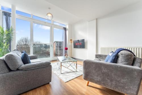 a living room with two couches and a glass table at Birmingham City Centre Sunset Park Free Parking in Birmingham
