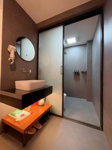 a bathroom with a sink and a shower with a mirror at 四时了了民宿 in Zhangjiajie