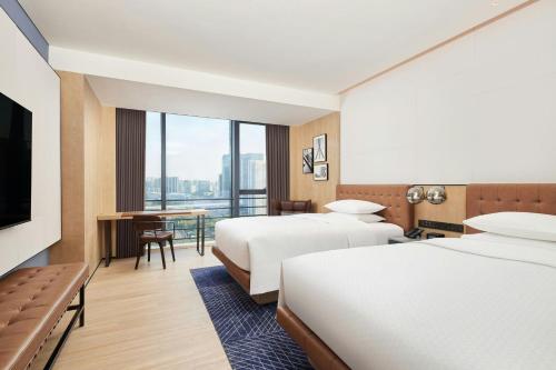 una camera d'albergo con due letti e una televisione di Four Points by Sheraton Shenzhen, Guangming a Shenzhen