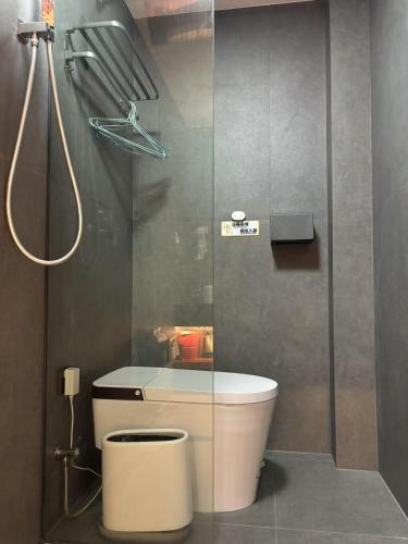 a bathroom with a toilet and a glass shower at 四时了了民宿 in Zhangjiajie