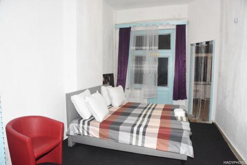 a bedroom with a bed and a red chair at Hébergement confort Garé de l'ouest in Brussels