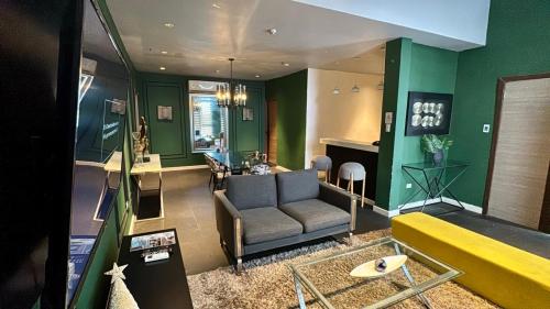 a living room with a couch and green walls at City Park Hotel Residences in Manila