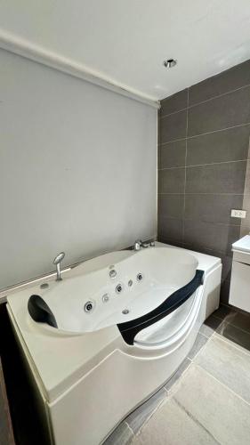 a white bath tub sitting in a bathroom at City Park Hotel Residences in Manila
