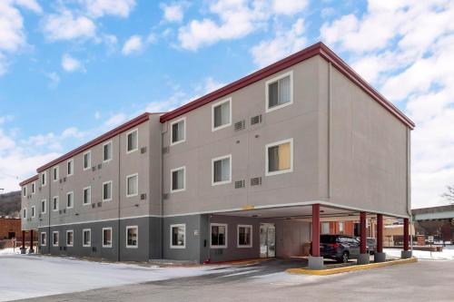 a large gray building with a parking lot at Red Roof Inn Johnstown in Johnstown