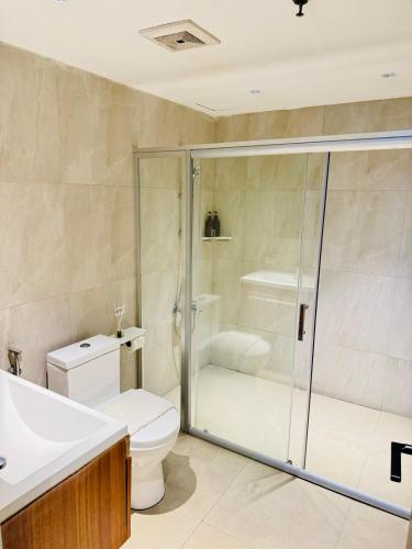 a bathroom with a shower and a toilet and a sink at City Park Hotel Residences in Manila