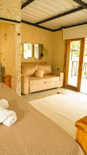 a bedroom with two beds and a couch at Gulungos Refugio Natural in Cisneros