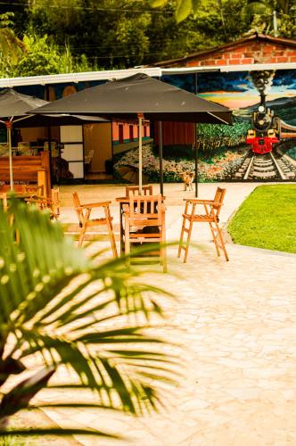 a group of tables and chairs with an umbrella at Gulungos Refugio Natural in Cisneros