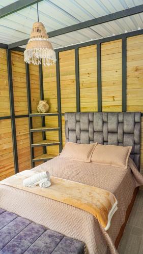 a bedroom with a large bed with a chandelier at Gulungos Refugio Natural in Cisneros