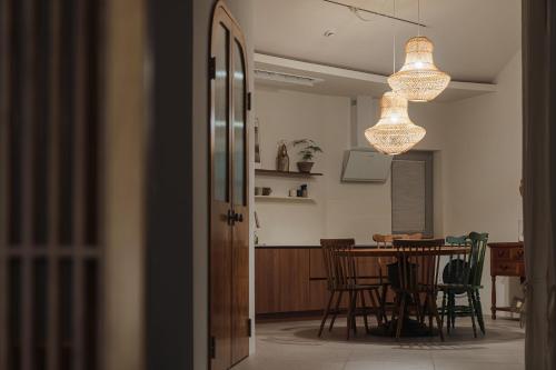 a dining room and kitchen with a table and a chandelier at Better than good in Jeju