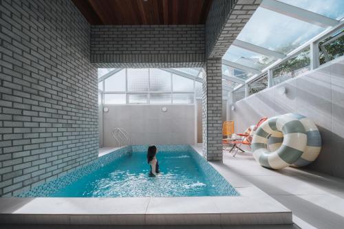 a child in a swimming pool with a lifebuoy at Better than good in Jeju