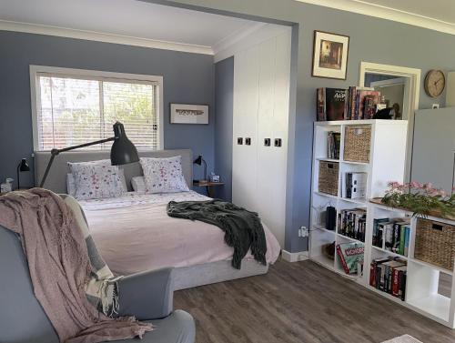 ein Schlafzimmer mit einem Bett und einem Bücherregal in der Unterkunft Blue Gate Cottage in Indigo Upper