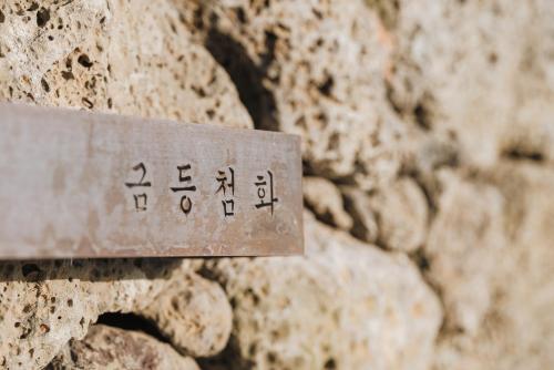 a metal sign on the side of a rock at Better than good in Jeju