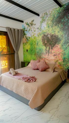 a bedroom with a bed with a painting on the wall at Gulungos Refugio Natural in Cisneros