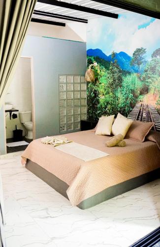 a bedroom with a large bed with a painting on the wall at Gulungos Refugio Natural in Cisneros