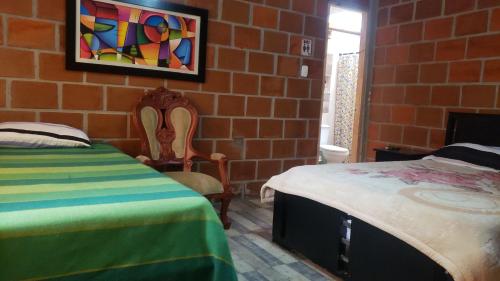 a bedroom with a bed and a brick wall at Hospedaje rural y restaurante in Santa Rosa de Cabal