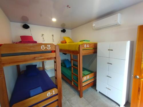 a room with two bunk beds and a desk at Casajungla Hostel in Jacó