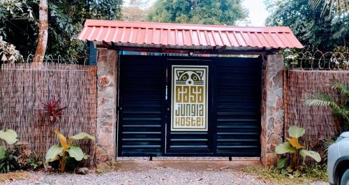 a black garage with a sign on the door at Casajungla Hostel in Jacó