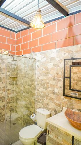 a bathroom with a toilet and a glass shower at Gulungos Refugio Natural in Cisneros