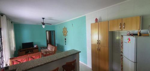 eine Küche mit blauen Wänden und einem Kühlschrank in der Unterkunft Microcasa Mar Verde in Caraguatatuba