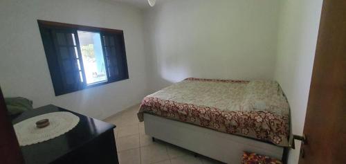 ein kleines Schlafzimmer mit einem Bett und einem Fenster in der Unterkunft Microcasa Mar Verde in Caraguatatuba