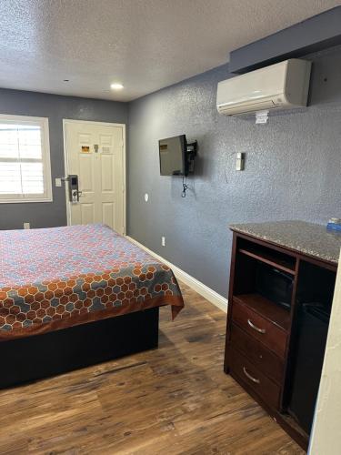 a bedroom with a bed and a dresser and a sink at Fireside Inn By The Beach Boardwalk & Bowling in Santa Cruz
