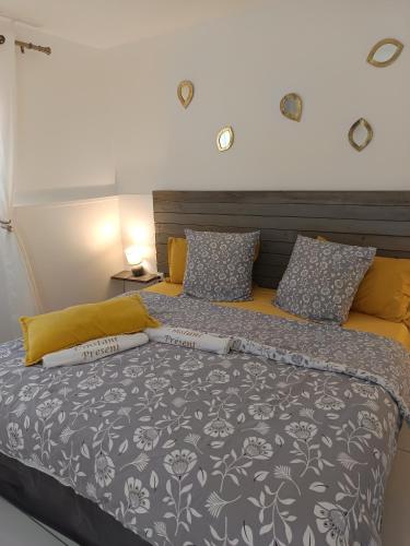 a bedroom with a large bed with a gray and white comforter at L'INSTANT PRESENT in Le Moule