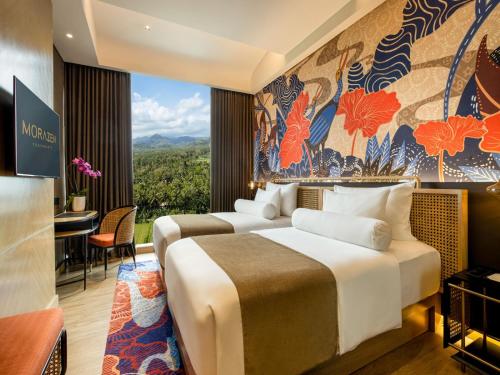two beds in a hotel room with a view at MORAZEN Yogyakarta in Temon