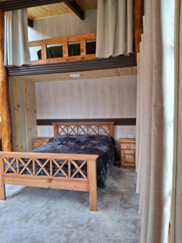 a bedroom with a wooden bed in a room at alojamientos CM in Tolhuin